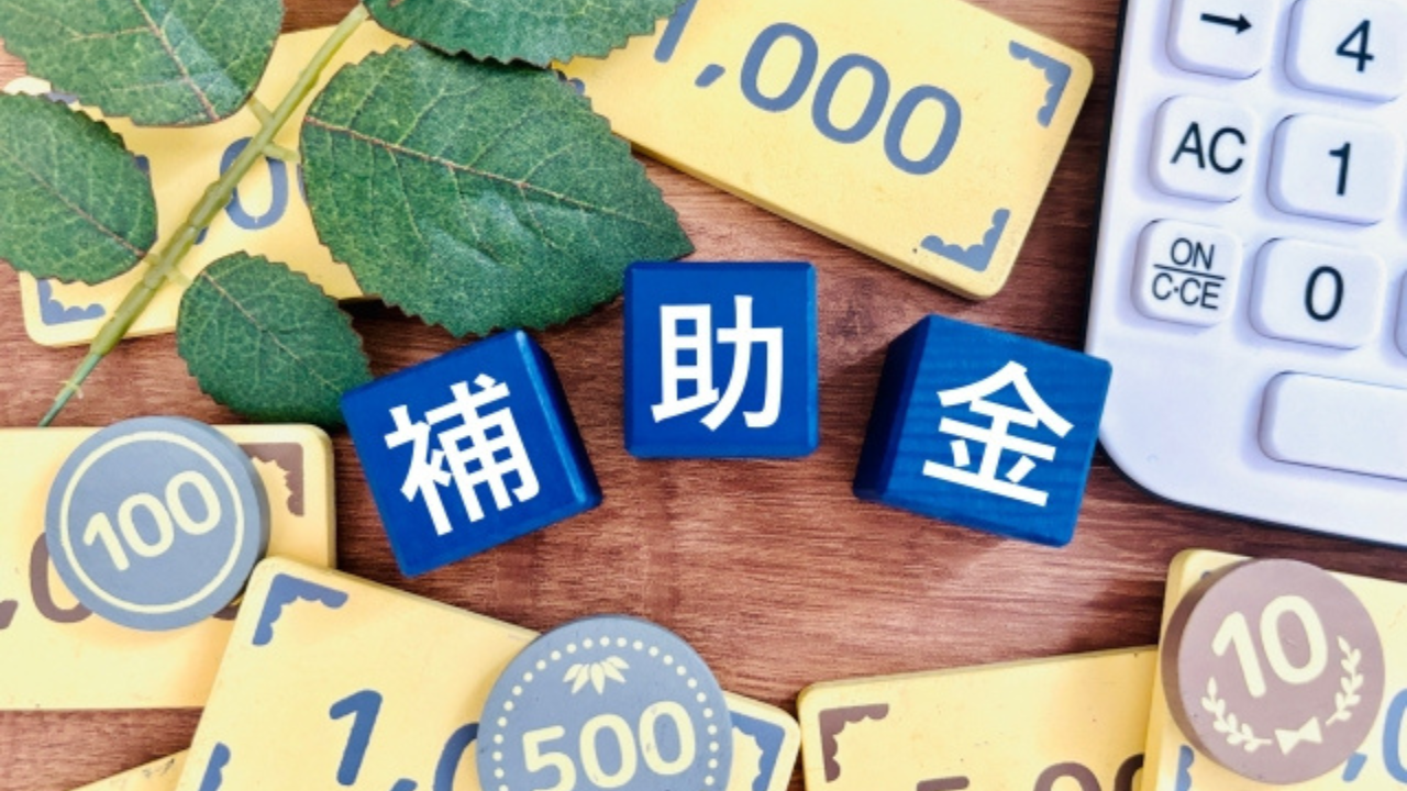 補助金等の情報お知らせ記事に使用した補助金のサイコロとおもちゃのお金が並んだ画像