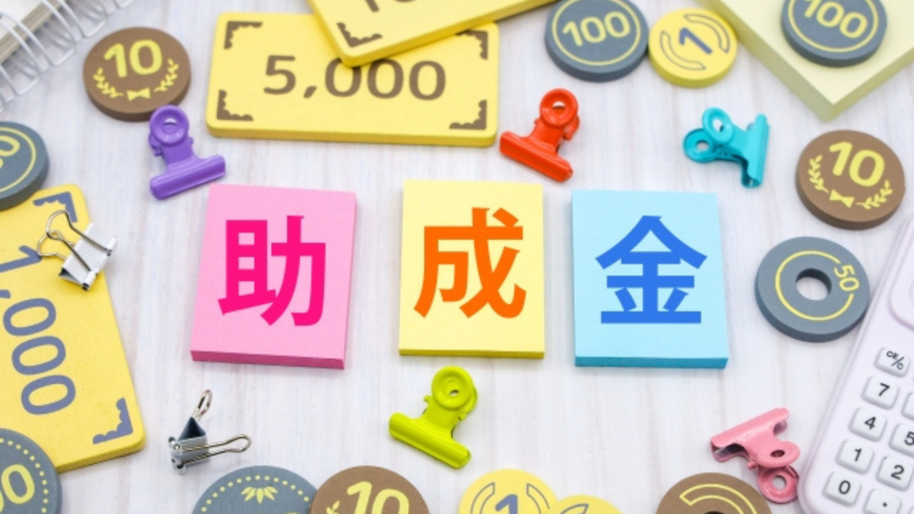 補助金等の情報お知らせ記事に使用した助成金と書かれたカラフルな文字とおもちゃのお金が並んだ画像